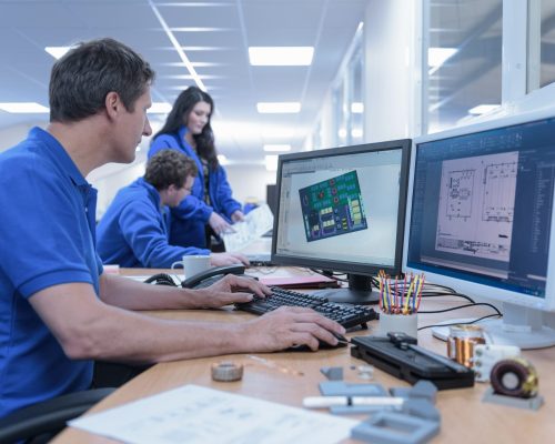 Electronics designers with CAD imagery in electronics factory Electronics designers with CAD imagery in electronics factory