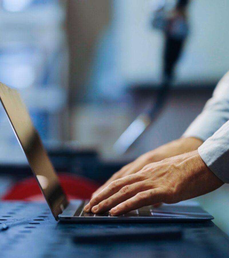 Programming robot controller, Programming robotic arms in factory industrial, Robotic arms in production line, Engineer specialist using laptop checking machine in factory, Engineer coding robot